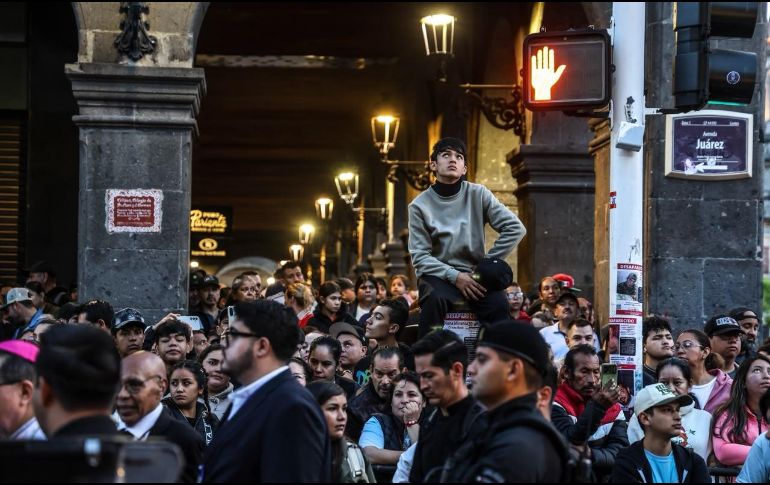 Bajo los portales de la Avenida Juárez, cualquier rincón, poste o cornisa es un buen punto para contemplar el paso de La Generala y con una mirada que refleja el sentimiento del pueblo tapatío, que espera con paciencia su encuentro con la imagen sagrada. EL INFORMADOR / A. Navarro