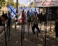 El palestino Mouayad Oweis y sus hijos tratan de retirar astas de bandera colocadas por colonos israelíes para bloquear el acceso a su cafetería en el poblado de al-Lubban al-Sharqiya, Cisjordania, el jueves 8 de octubre de 2026. AP/ Leo Correa