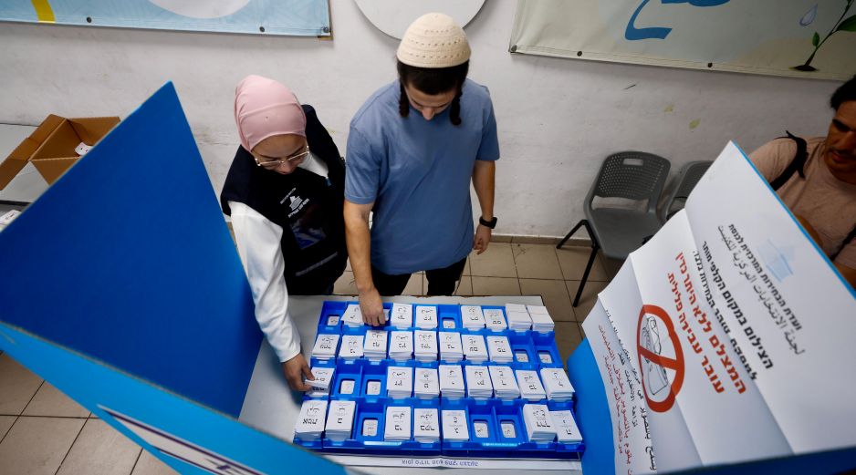 Dos personas eligen las papeletas para votar en un colegio electoral en Umm al-Fahm, Israel, el 27 de octubre de 2026. EFE/J. Awad