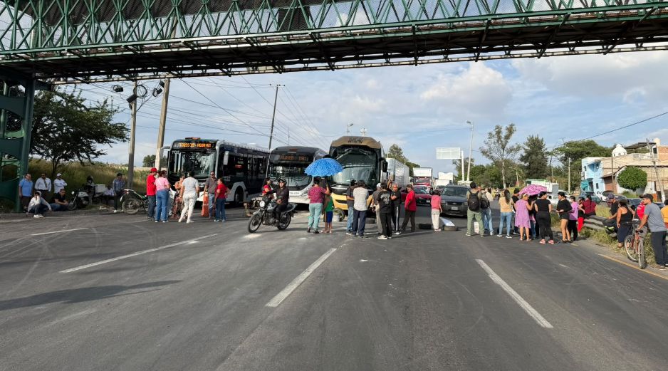 Al menos una decena de personas bloqueó este martes tres carriles de la Carretera a Chapala con pancartas en mano, llantas, tierra y sillas. EL INFORMADOR
