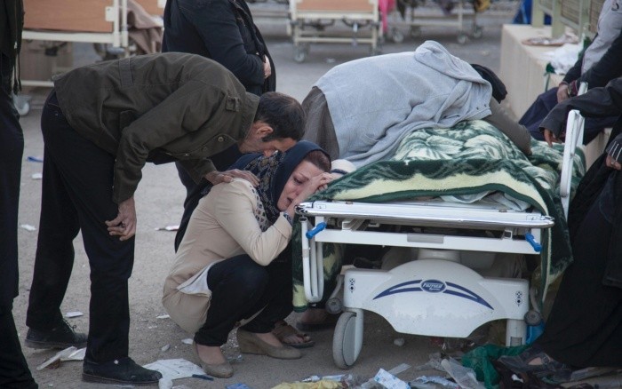 Varias personas lloran junto a uno de los cuerpos rescatados esta mañana. AFP/F. Menati
