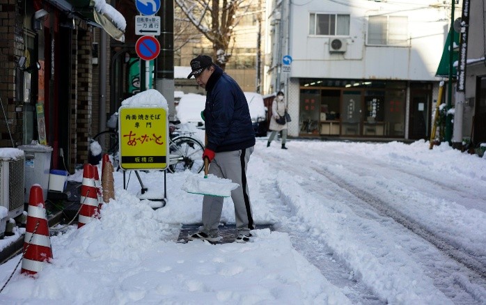 Un hombre despeja la nieve de una acera después de una nevada en Tokio. EFE/F. Robichon