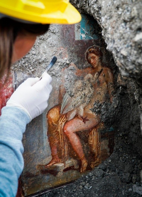 CORRECTS TITLE OF THE FIGURE SHOWN IN THE FRESCO - CORRECTS TITLE OF THE FIGURE SHOWN IN THE FRESCO, FROM GODDESS TO QUEEN OF SPARTA - An archeologist cleans up the fresco ''Leda e il cigno'' (Leda and the swan) discovered last Friday in the Regio V archeological area in Pompeii, near Naples, Italy, Monday, Nov. 19, 2018. The fresco depicts a story and art subject of Greek mythology, with Queen of Sparta Leda being impregnated by Zeus -  Jupiter in Roman mythology - in the form of a swan. (Cesare Abbate/ANSA via AP) CORRECTION APTOPIX Italy Pompeii Fresco - CORRECTS TITLE OF THE FIGURE SHOWN IN THE FRESCO, FROM GODDESS TO QUEEN OF SPARTA . ITALY OUT