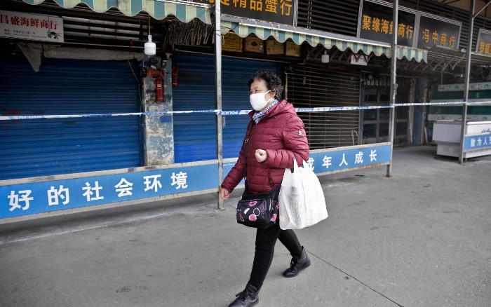 Wuhan (China), 20/01/2020.- A woman wears a mask while walking past the closed Huanan Seafood Wholesale Market, which has been linked to cases of a new strain of Coronavirus identified as the cause of the pneumonia outbreak in Wuhan, Hubei province, China, 20 January 2020. China reported on 20 January an additional death and surge of 139 new confirmed cases of the mysterious SARS-like virus linked to the Wuhan pneumonia outbreak, bringing the total number of cases to 198 with three deaths so far. EFE/EPA/STR CHINA OUT China confirms third victim, 139 new cases of viral pneumonia-CHINA OUT
