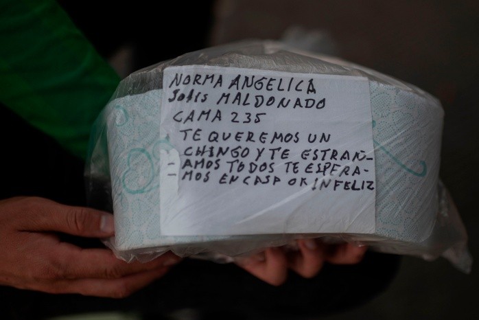 TOPSHOT - A woman shows a personal message she sends in a package of toilet paper to a relative infected with COVID-19 who remains in La Raza medical center, in Mexico City on April 29, 2020. Handwritten notes are the thread of communication between patients infected with coronavirus and their relatives in the Mexican capital. / AFP / PEDRO PARDO TOPSHOTS-TOPSHOT-MEXICO-HEALTH-VIRUS-TO GO WITH AFP STORY BY NATALIA CANO