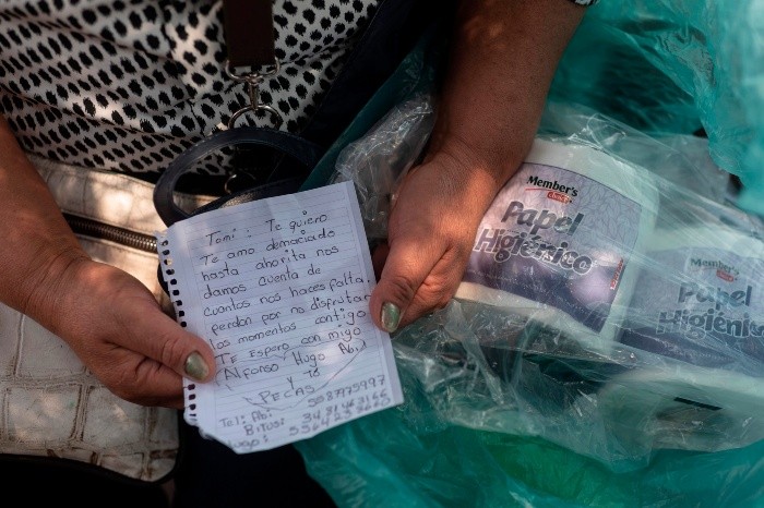 A woman shows a personal message she sends in a package of toilet paper to a relative infected with COVID-19 who remains in La Raza medical center, in Mexico City on April 29, 2020. Handwritten notes are the thread of communication between patients infected with coronavirus and their relatives in the Mexican capital. / AFP / PEDRO PARDO MEXICO-HEALTH-VIRUS-TO GO WITH AFP STORY BY NATALIA CANO
