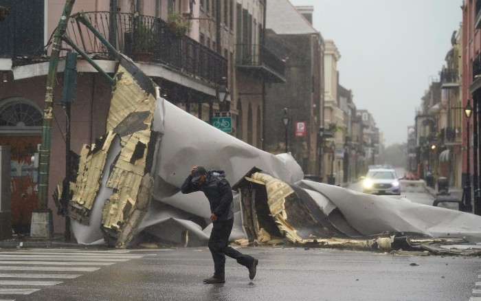 A man passes by a section of roof that was blown off of a building in the French Quaeter by Hurricane Ida winds, Sunday, Aug. 29, 2021, in New Orleans. (AP Photo/Eric Gay)