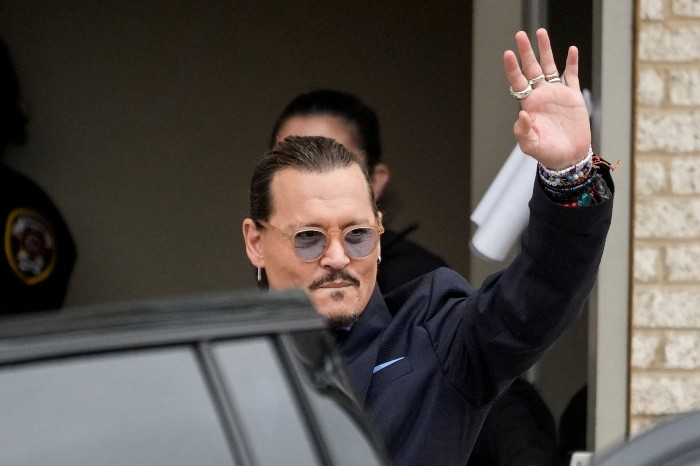 (FILES) In this file photo taken on May 27, 2022 US actor Johnny Depp waves to fans as he departs the Fairfax County Courthouse in Fairfax, Virginia. A US jury found June 1, 2022 that actress Amber Heard had made defamatory claims of abuse against her ex-husband Johnny Depp, and awarded him $15 million in damages. (Photo by Drew Angerer / GETTY IMAGES NORTH AMERICA / AFP)