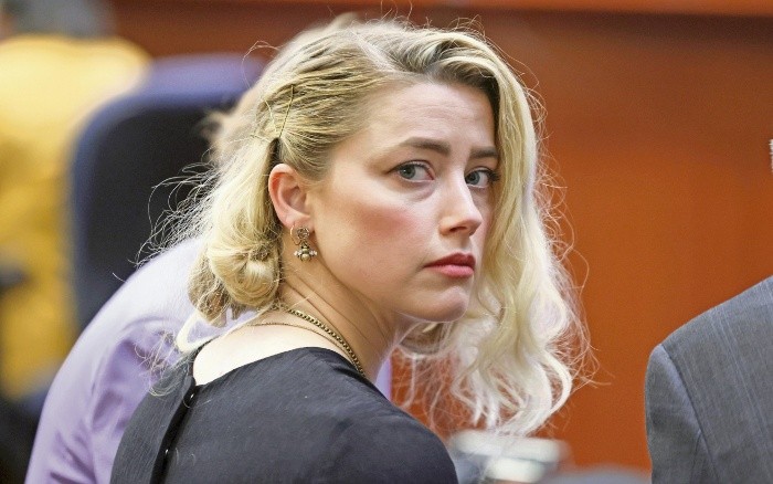 Actor Amber Heard waits before the verdict was read at the Fairfax County Circuit Courthouse in Fairfax, Va, Wednesday, June 1, 2022. The jury awarded Johnny Depp more than $10 million in his libel lawsuit against ex-wife Amber Heard. It vindicates his stance that Heard fabricated claims that she was abused by Depp before and during their brief marriage. But the jury also found in favor of Heard, who said she was defamed by a lawyer for Depp.(Evelyn Hockstein/Pool via AP)-pool image