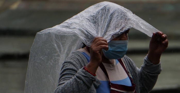 MEX5141.OAXACA, (MÉXICO), 30/05/2022.- Una mujer se protege de la lluvia hoy, en el estado de Oaxaca (Mexico). El huracán Ágatha, de categoría 2 y formado en el Pacíífico mexicano, tocó tierra este lunes en el sureño estado mexicano de Oaxaca dejando lluvias en el sur y sureste del país, informó el Servicio Meteorológico Nacional (SMN). EFE/Daniel Ricardez