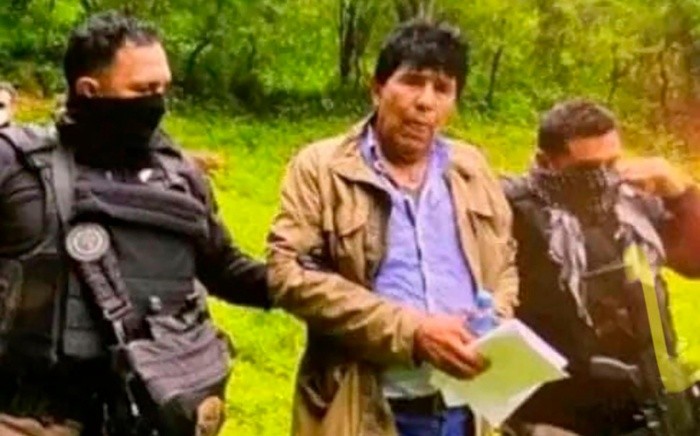 In this government handout photo provided by Mexico's Secretariat of the Navy, agents escort drug trafficker Rafael Caro Quintero, in Sinaloa state, Mexico, Friday, July 15, 2022, captured deep in the mountains of his home state. It was a 6-year-old bloodhound named “Max” who rousted Caro Quintero from the undergrowth. (Mexico's Secretariat of the Navy via AP)-BEST QUALITY AVAILABLE - AP PROVIDES ACCESS TO THIS PUBLICLY DISTRIBUTED HANDOUT PHOTO PROVIDED BY SECRETARIAT OF THE NAVY; MANDATORY CREDIT.